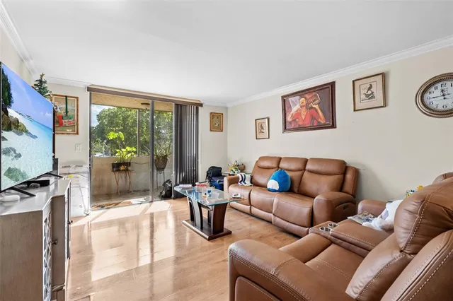 a living room with furniture a flat screen tv and a window