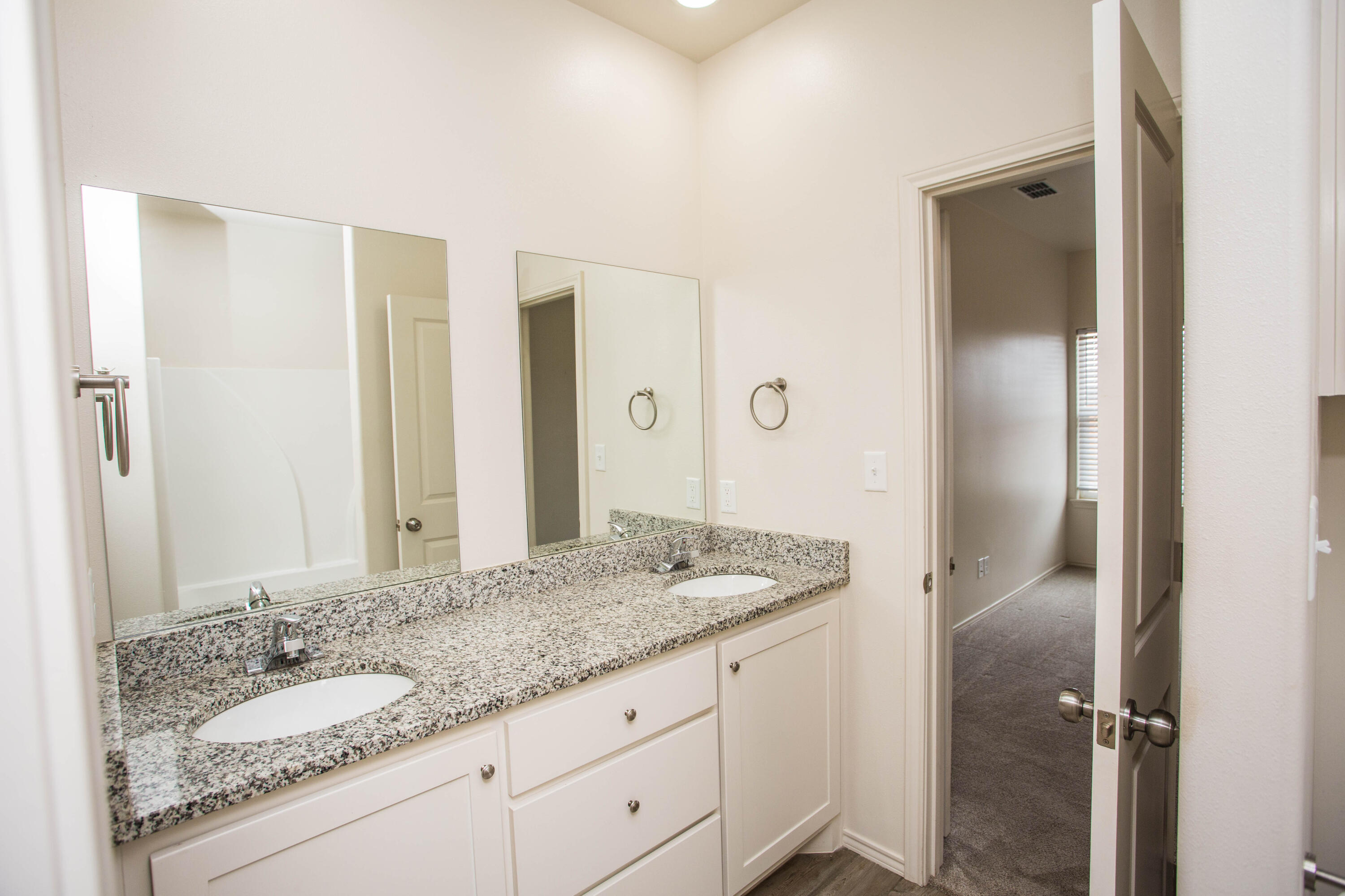 5613 Kemper Street Lubbock, TX 79416 - Photo 11 of 35 a bathroom with a granite countertop sink and a mirror