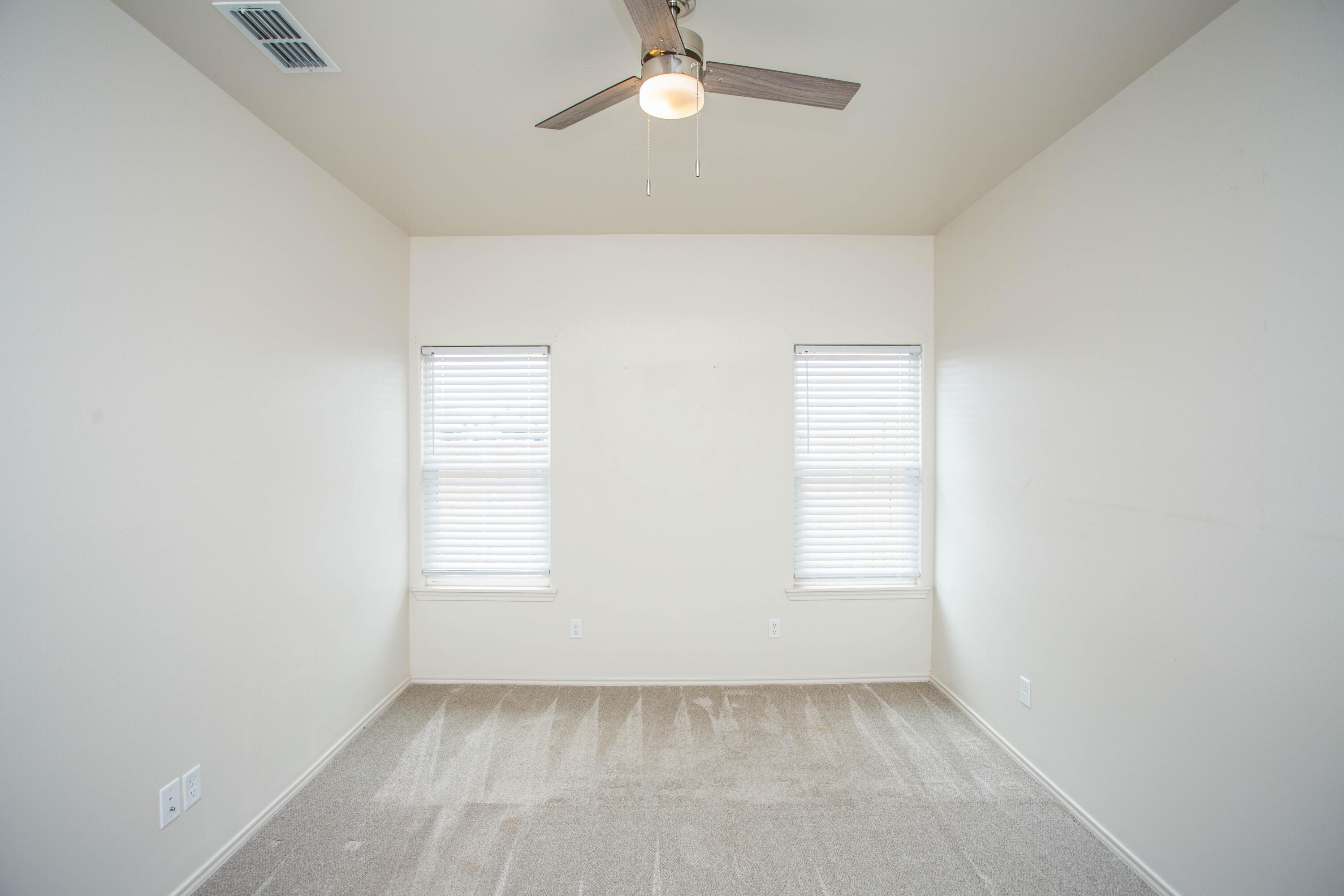 5613 Kemper Street Lubbock, TX 79416 - Photo 15 of 35 an empty room with windows and fan