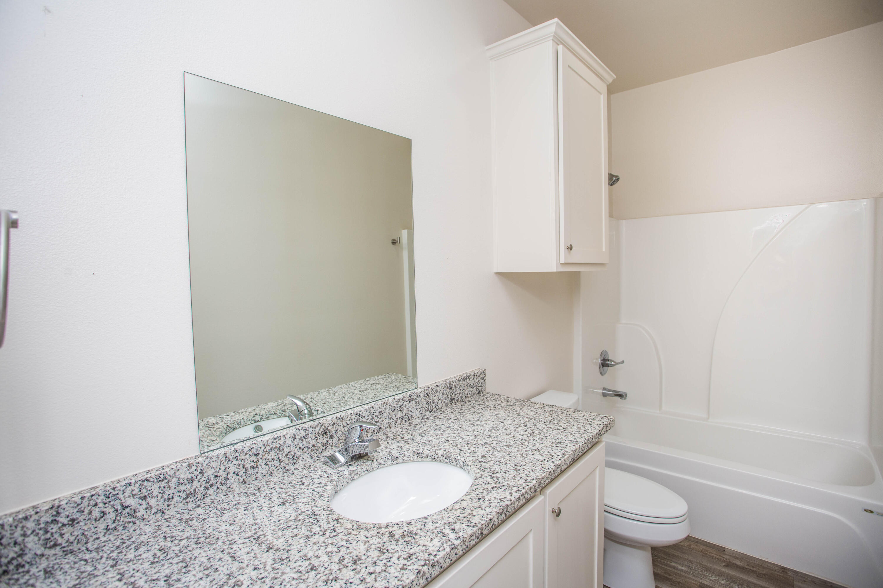 5613 Kemper Street Lubbock, TX 79416 - Photo 20 of 35 a bathroom with a granite countertop sink toilet and shower