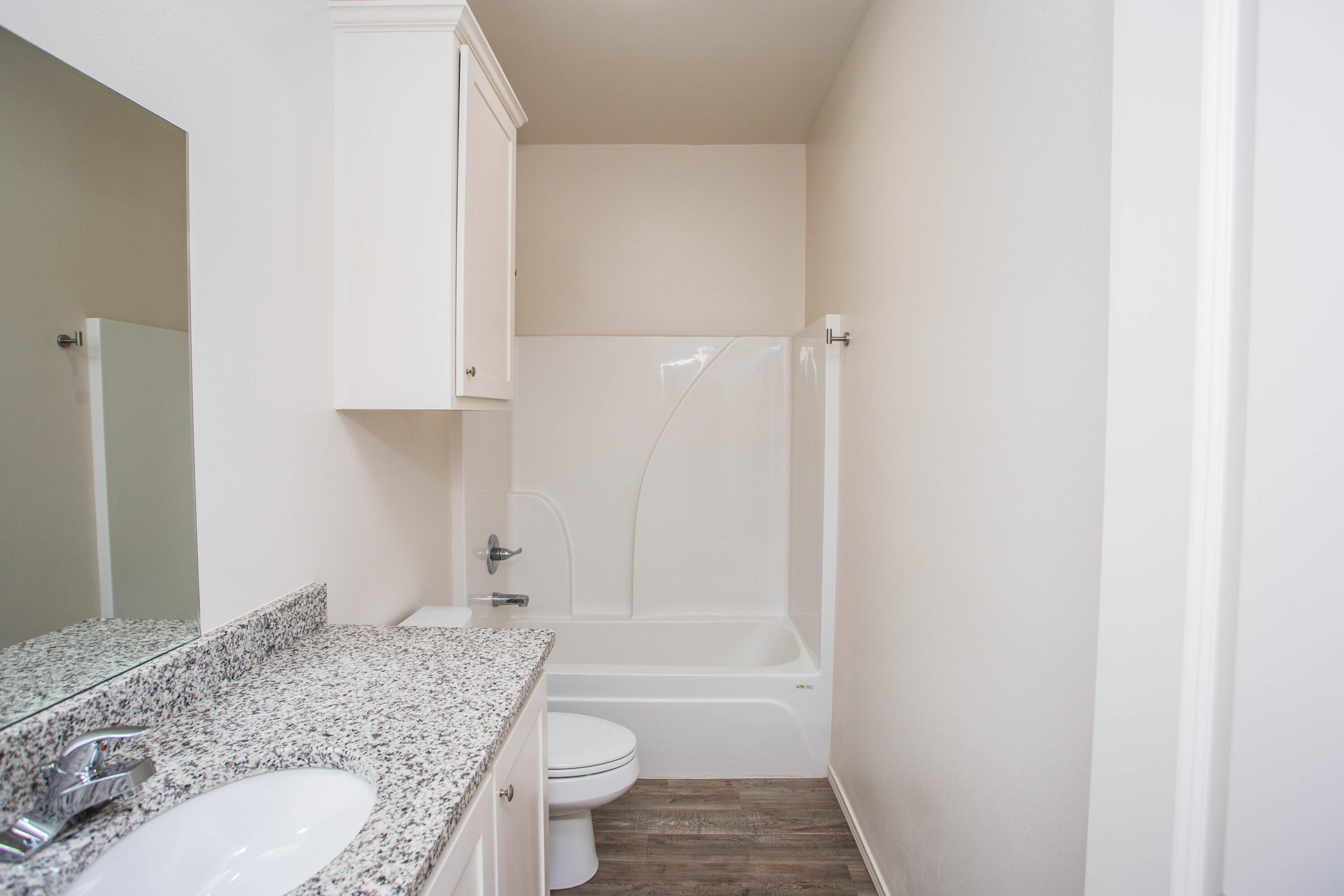 5613 Kemper Street Lubbock, TX 79416 - Photo 23 of 35 a bathroom with a granite countertop sink toilet and shower