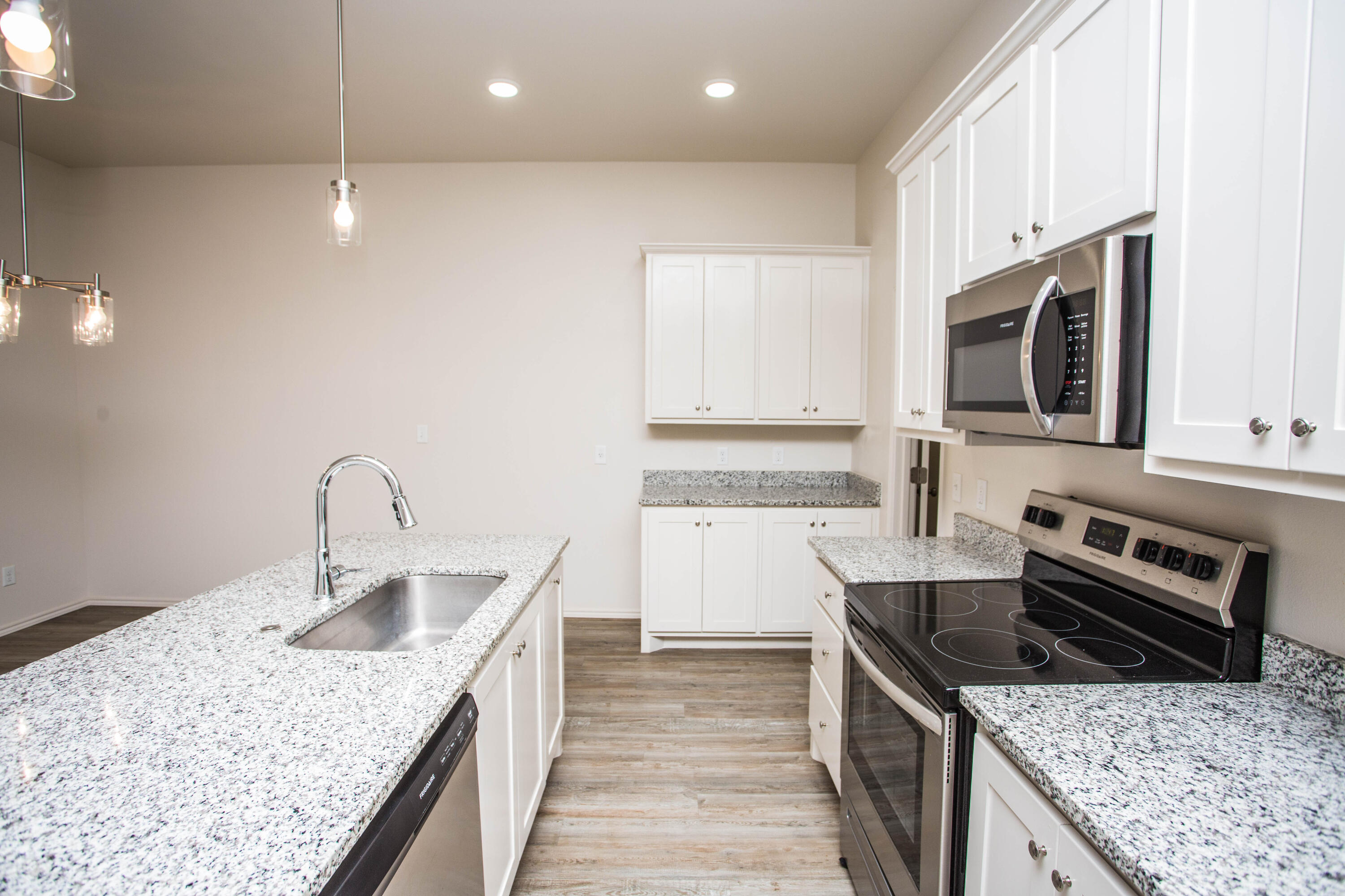 5613 Kemper Street Lubbock, TX 79416 - Photo 4 of 35 a kitchen with a stove sink and microwave