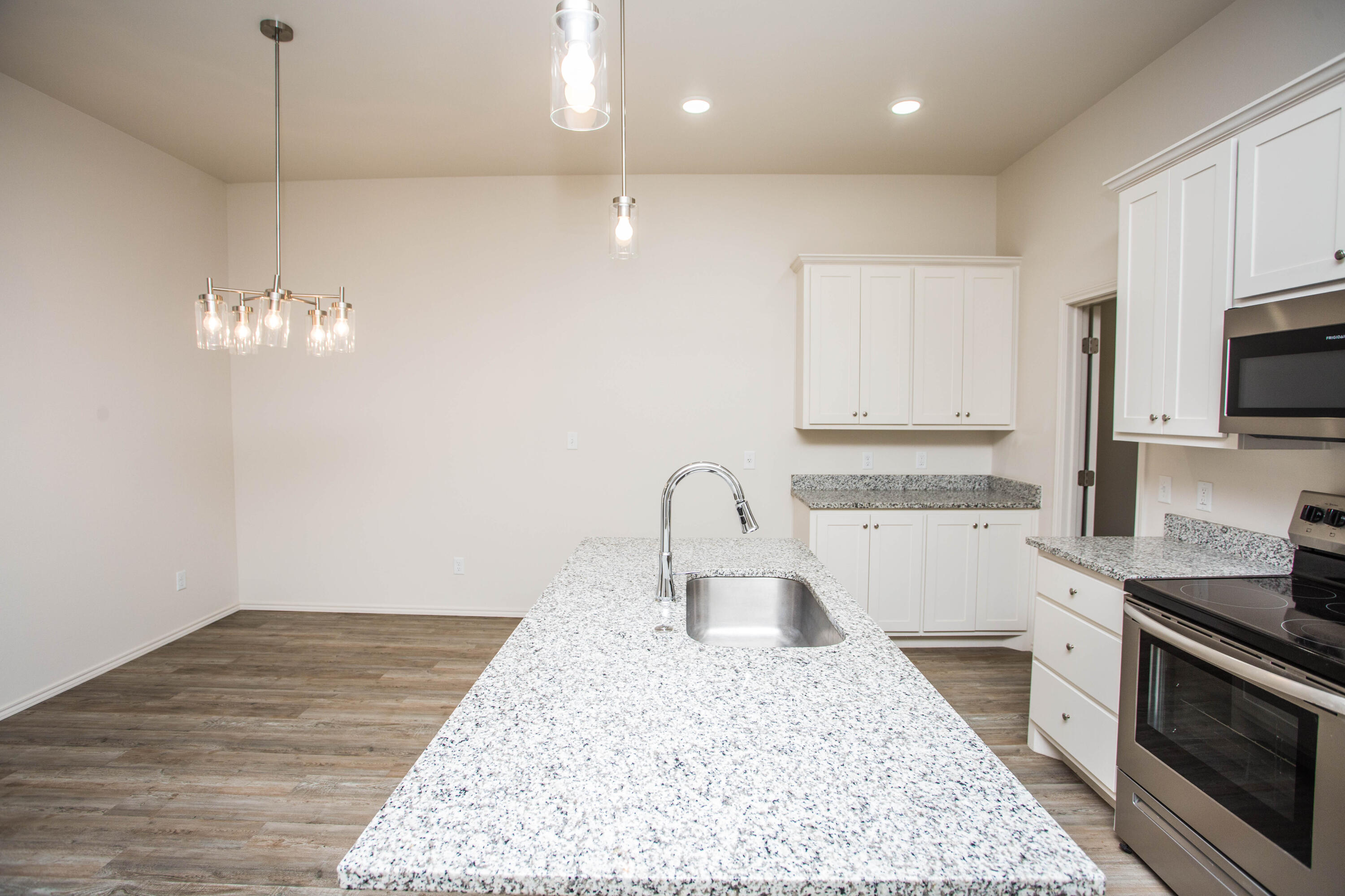 5613 Kemper Street Lubbock, TX 79416 - Photo 6 of 35 a kitchen with a sink granite counter tops and a stove