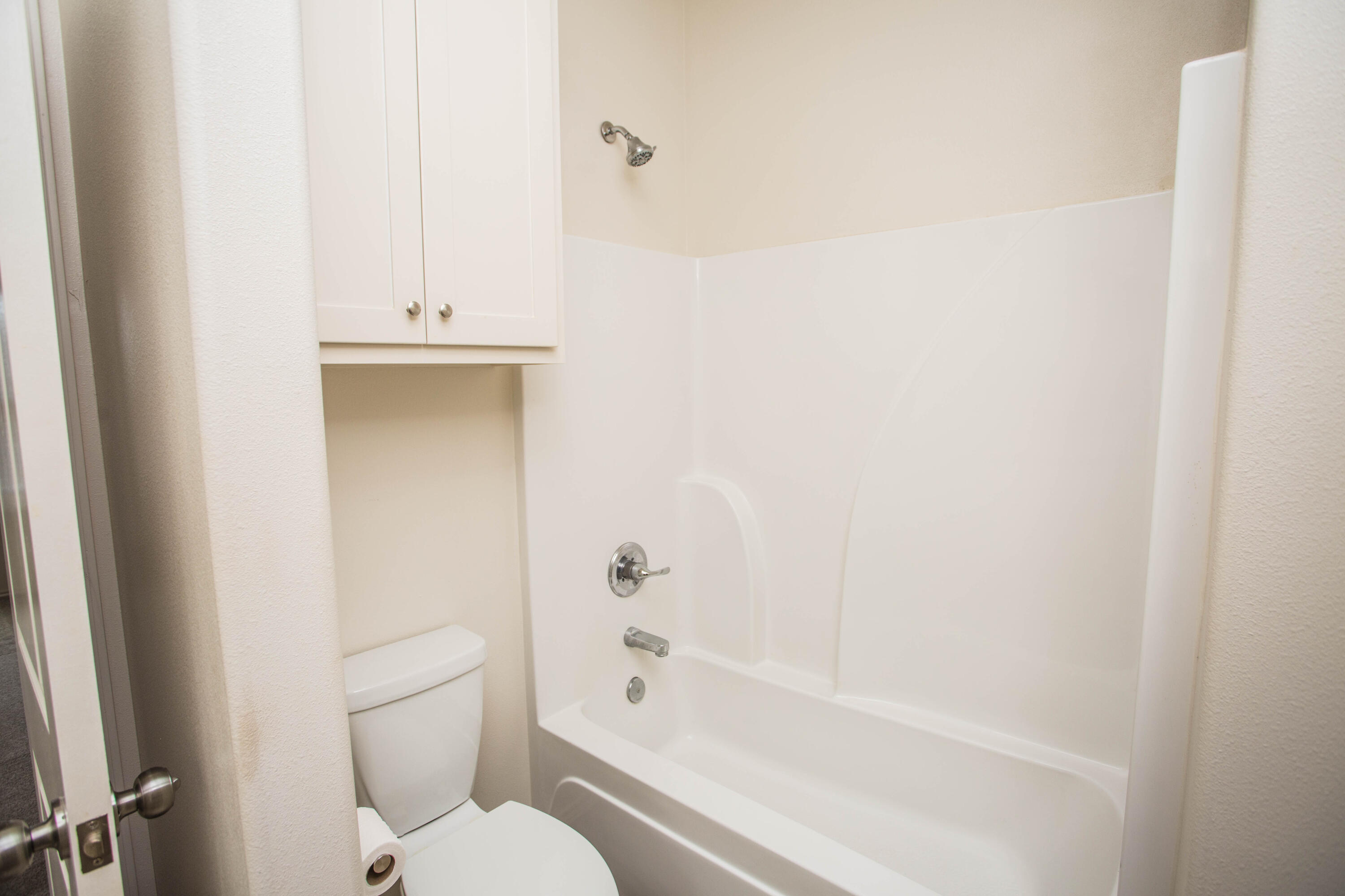 5613 Kemper Street Lubbock, TX 79416 - Photo 9 of 35 a bathroom with a toilet and a bathtub