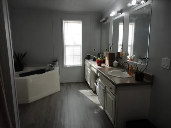 a bathroom with a double vanity sink a mirror and a bathtub