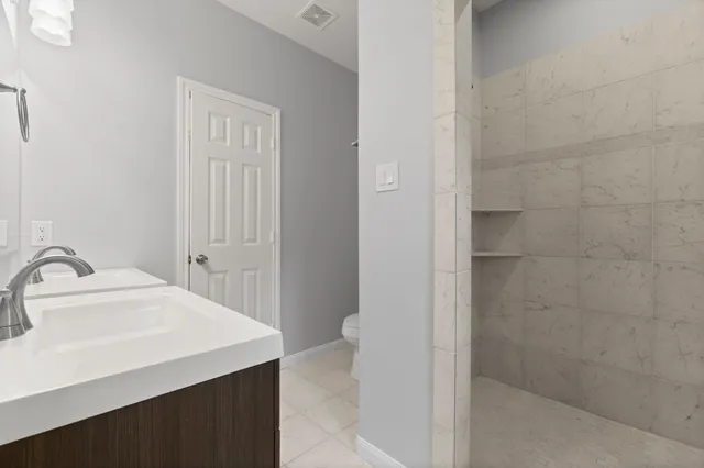 a bathroom with a sink a toilet and shower