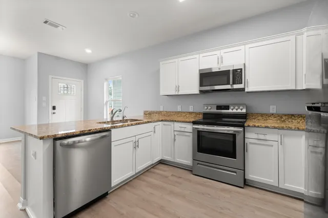 a kitchen with stainless steel appliances granite countertop a sink stove and microwave