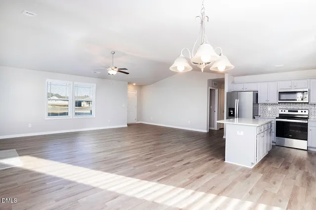 a kitchen with granite countertop a stove a sink and a microwave