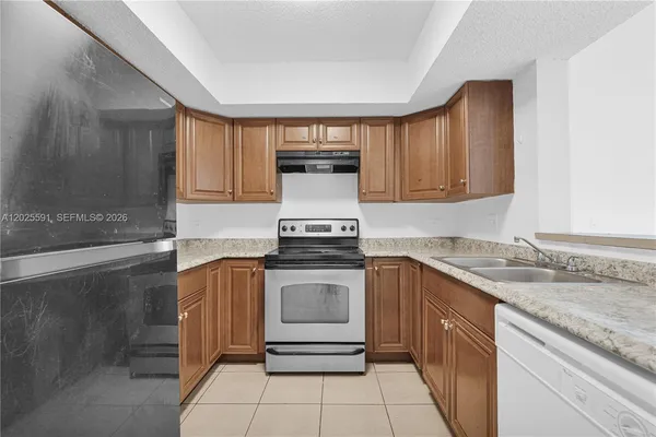 a kitchen with granite countertop a sink stove and cabinets