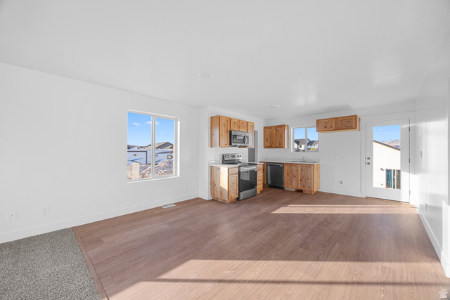 1563 South Deerbrook Road, Unit 267CHM Santaquin, UT 84655 - Photo 5 of 12 Open-concept living space featuring wood-finish flooring, white walls, and bright windows