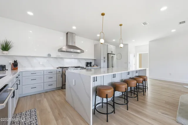a kitchen with stainless steel appliances granite countertop a stove and a wooden floors