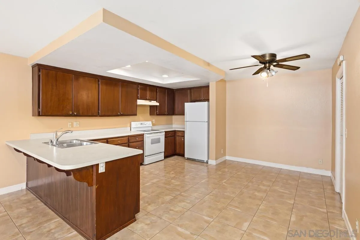 12027 Royal Road, Unit 3 El Cajon, CA 92021 - Photo 4 of 20 a kitchen with a sink a refrigerator and cabinets