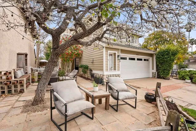 a view of a patio with a table and chairs and couches and wooden fence