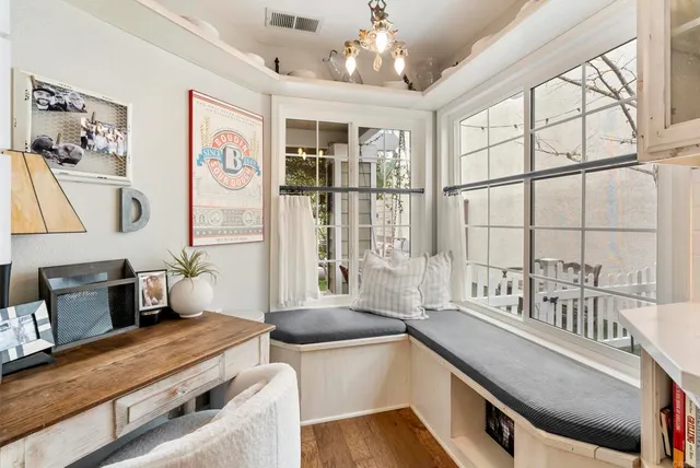 a dining room with wooden floor and a large window