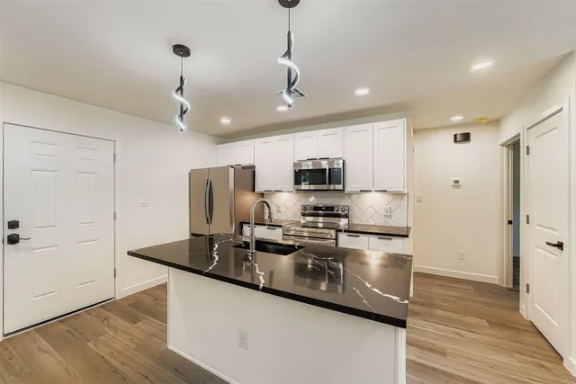 a view of kitchen with stainless steel appliances refrigerator microwave and cabinets