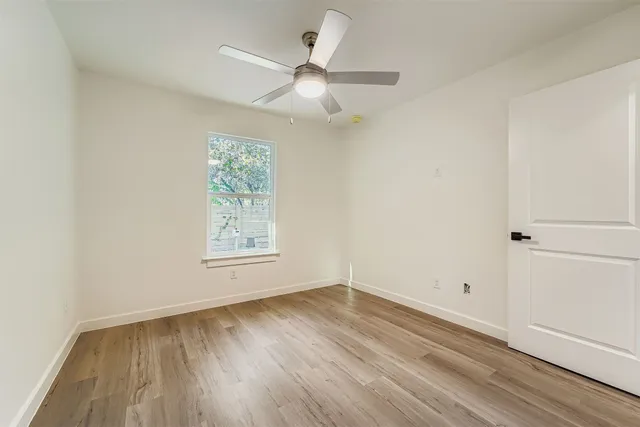 a view of a room with wooden floor and a ceiling fan