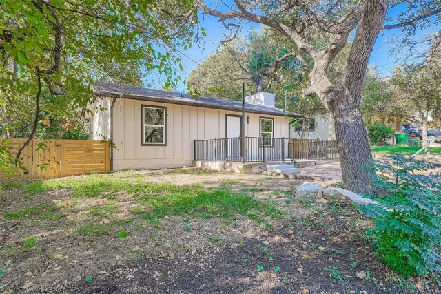 a view of a house with backyard and a tree