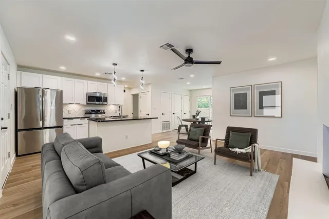 a large kitchen with stainless steel appliances a refrigerator and a stove top oven