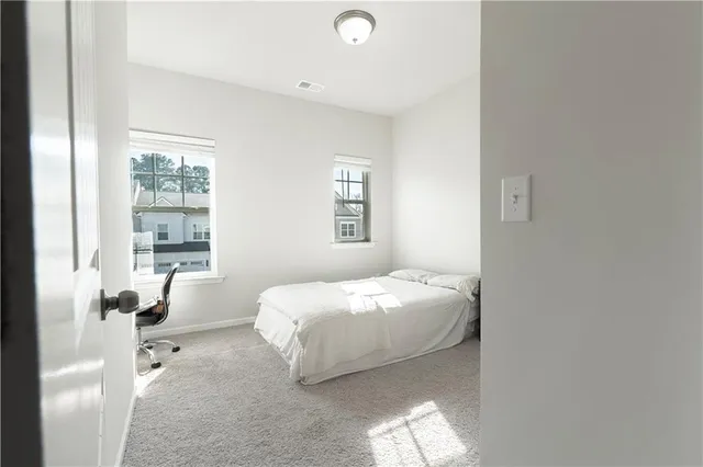 a bedroom with a bed and windows