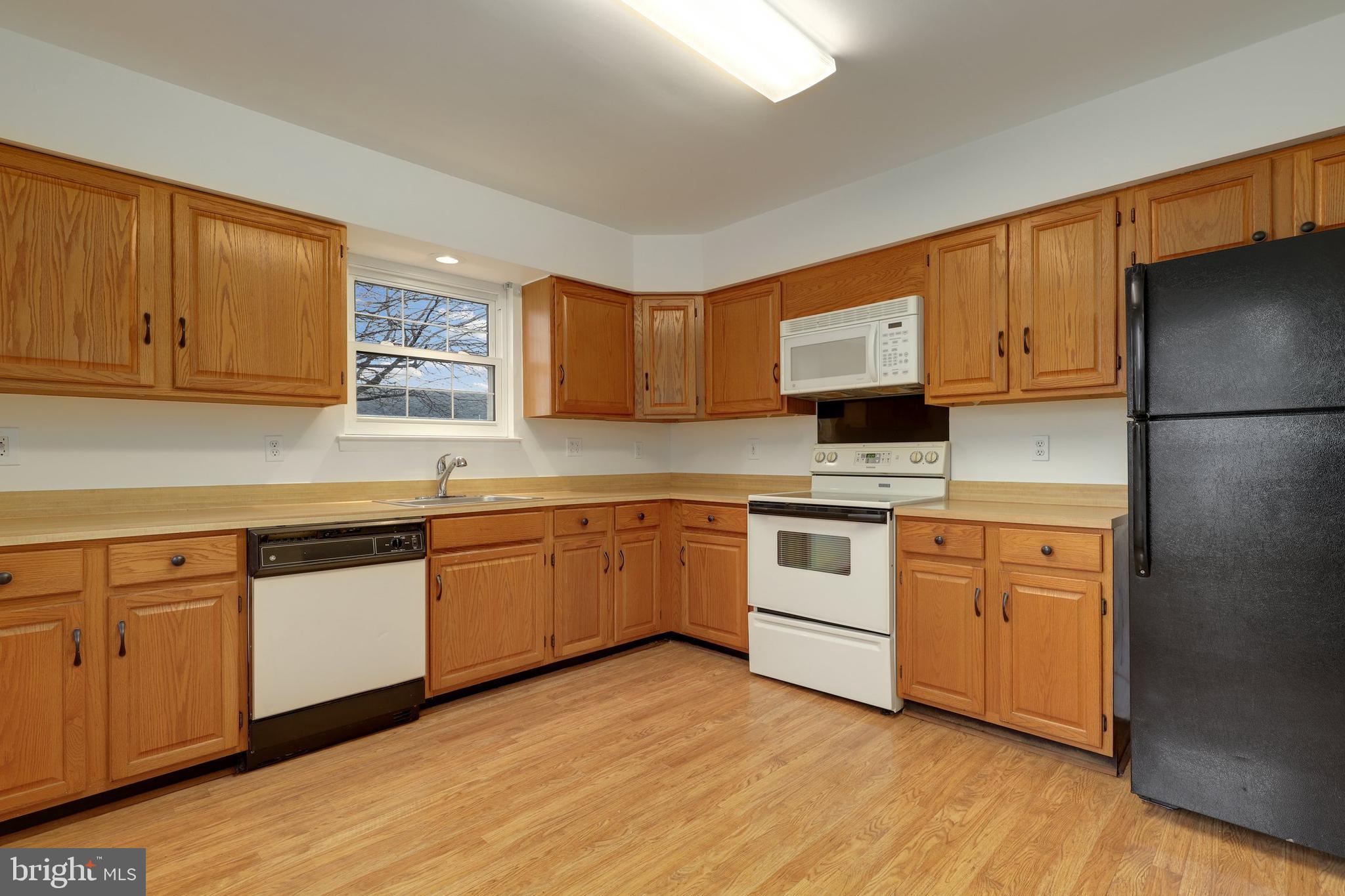 5652 Sandy Court Frederick, MD 21703 - Photo 13 of 35 a kitchen with granite countertop wooden cabinets and white appliances