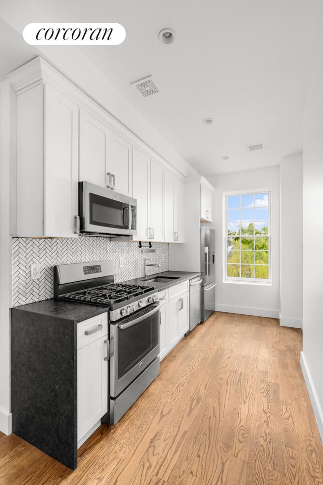 935 Lafayette Avenue, Unit 2 Brooklyn, NY 11221 - Photo 6 of 10 a kitchen with stainless steel appliances granite countertop a stove a sink and a microwave