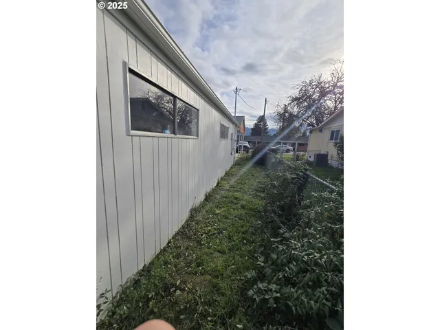 a backyard of a house with wooden fence and a window