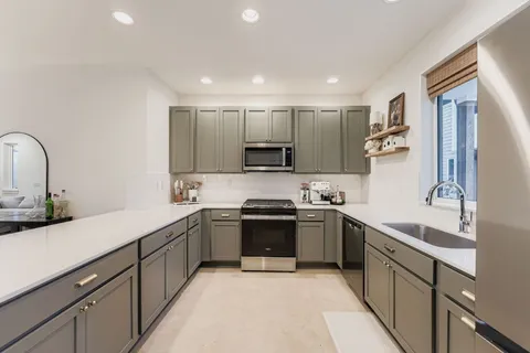 a kitchen with stainless steel appliances granite countertop a sink and cabinets