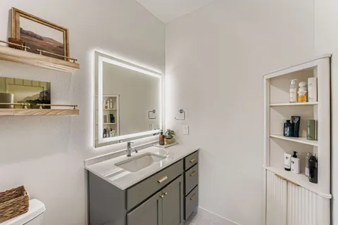 a bathroom with a sink a vanity and a mirror