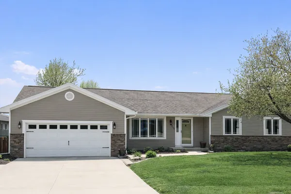 a front view of a house with a yard and trees