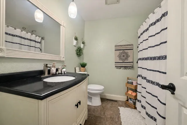 a bathroom with a sink a toilet and a mirror