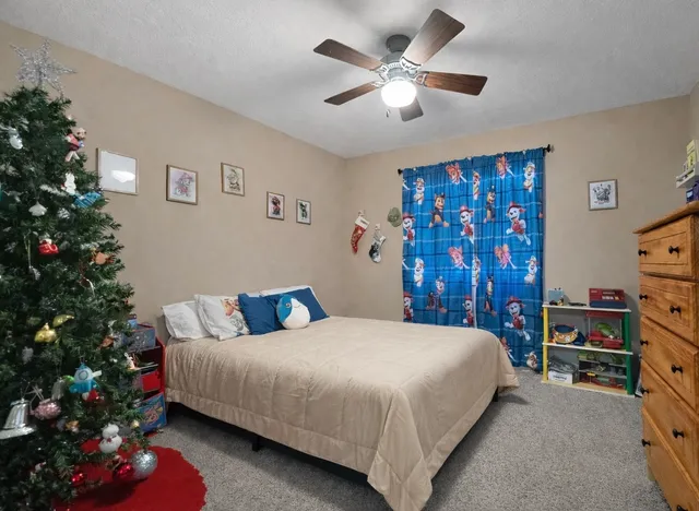 a bedroom with a bed window and a chandelier