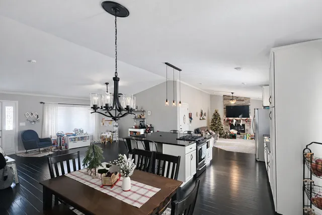 a view of a dining room and livingroom with furniture wooden floor a chandelier