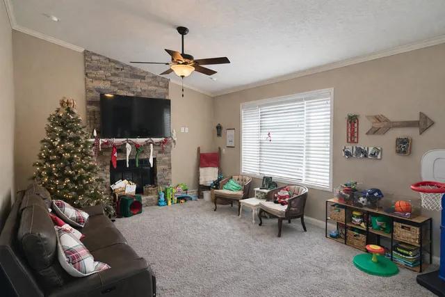 a living room with furniture a flat screen tv and a window