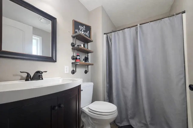 a bathroom with a sink a toilet and a mirror