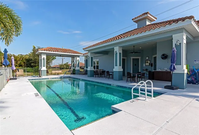 a view of a patio with couches table and chairs with swimming pool