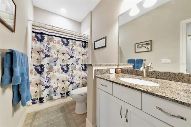 a bathroom with a granite countertop sink toilet and shower