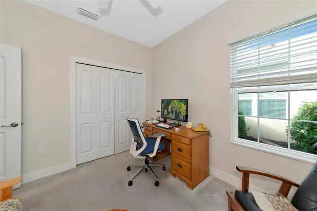 a view of a workspace with furniture and a window