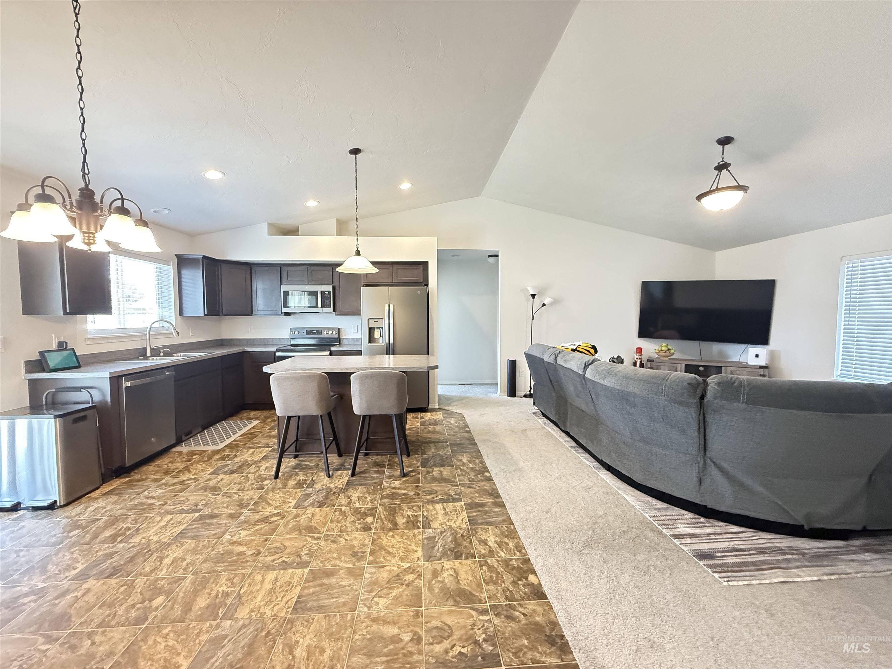 1556 Frontier Drive Lewiston, ID 83501 - Photo 12 of 23 Open-concept living area with vaulted ceilings and a blend of tile-patterned flooring and carpet