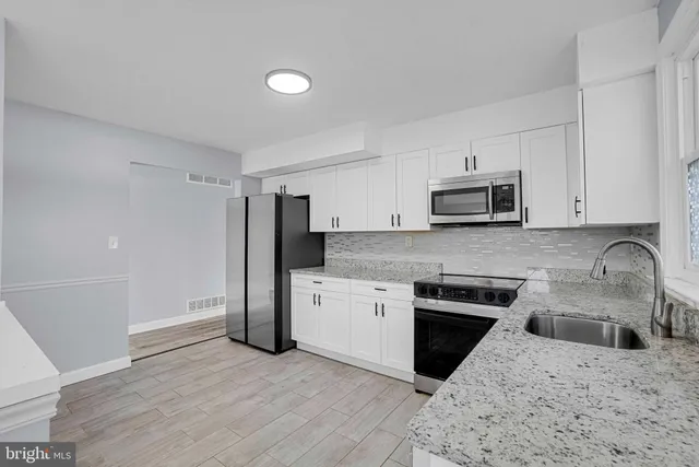 a kitchen with stainless steel appliances granite countertop a refrigerator stove and sink