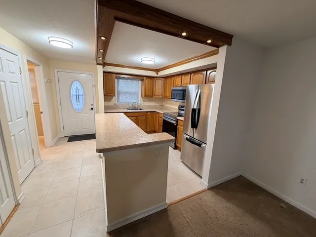 a kitchen with stainless steel appliances granite countertop a refrigerator and a stove