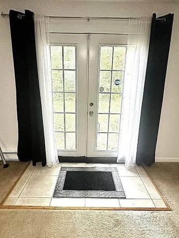 a view of a hallway with white cabinets and dryer