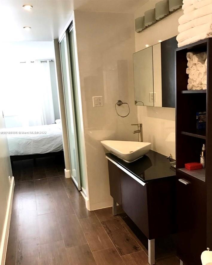 9511 Collins Avenue, Unit 308 Surfside, FL 33154 - Photo 13 of 14 a bathroom with a sink a mirror and a bathtub