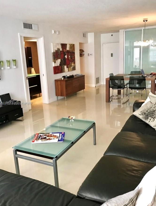 9511 Collins Avenue, Unit 308 Surfside, FL 33154 - Photo 8 of 14 a living room with furniture and a flat screen tv