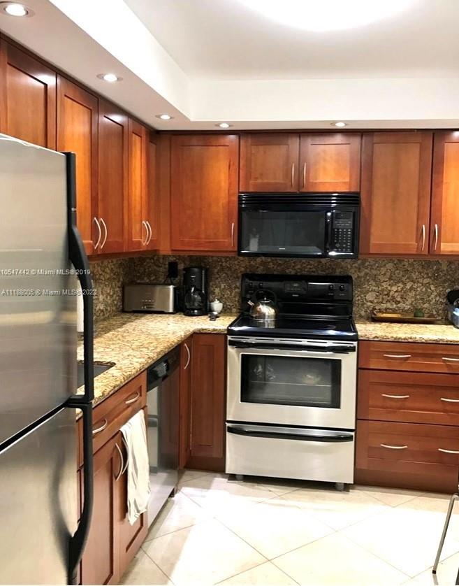 9511 Collins Avenue, Unit 308 Surfside, FL 33154 - Photo 10 of 14 a kitchen with granite countertop a stove and a microwave