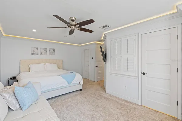 a spacious bedroom with a bed and a ceiling fan