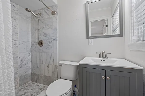 a bathroom with a sink a toilet and shower