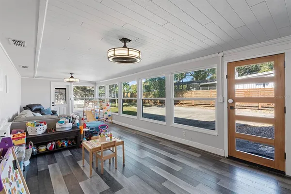 a living room with furniture a rug potted plant and a large window