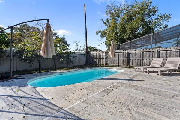 a view of a backyard with couches and wooden fence