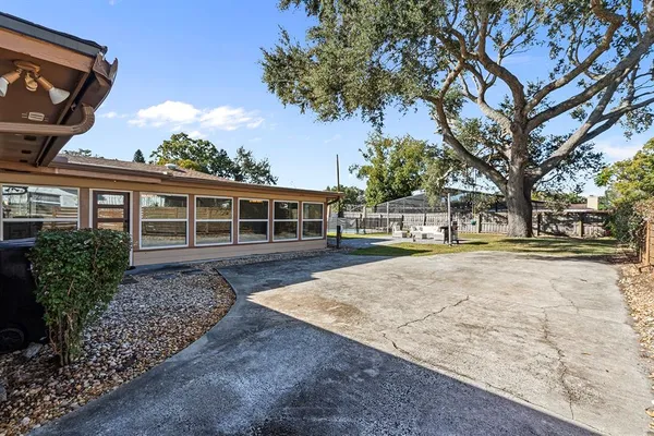 a view of a house with a yard and large tree