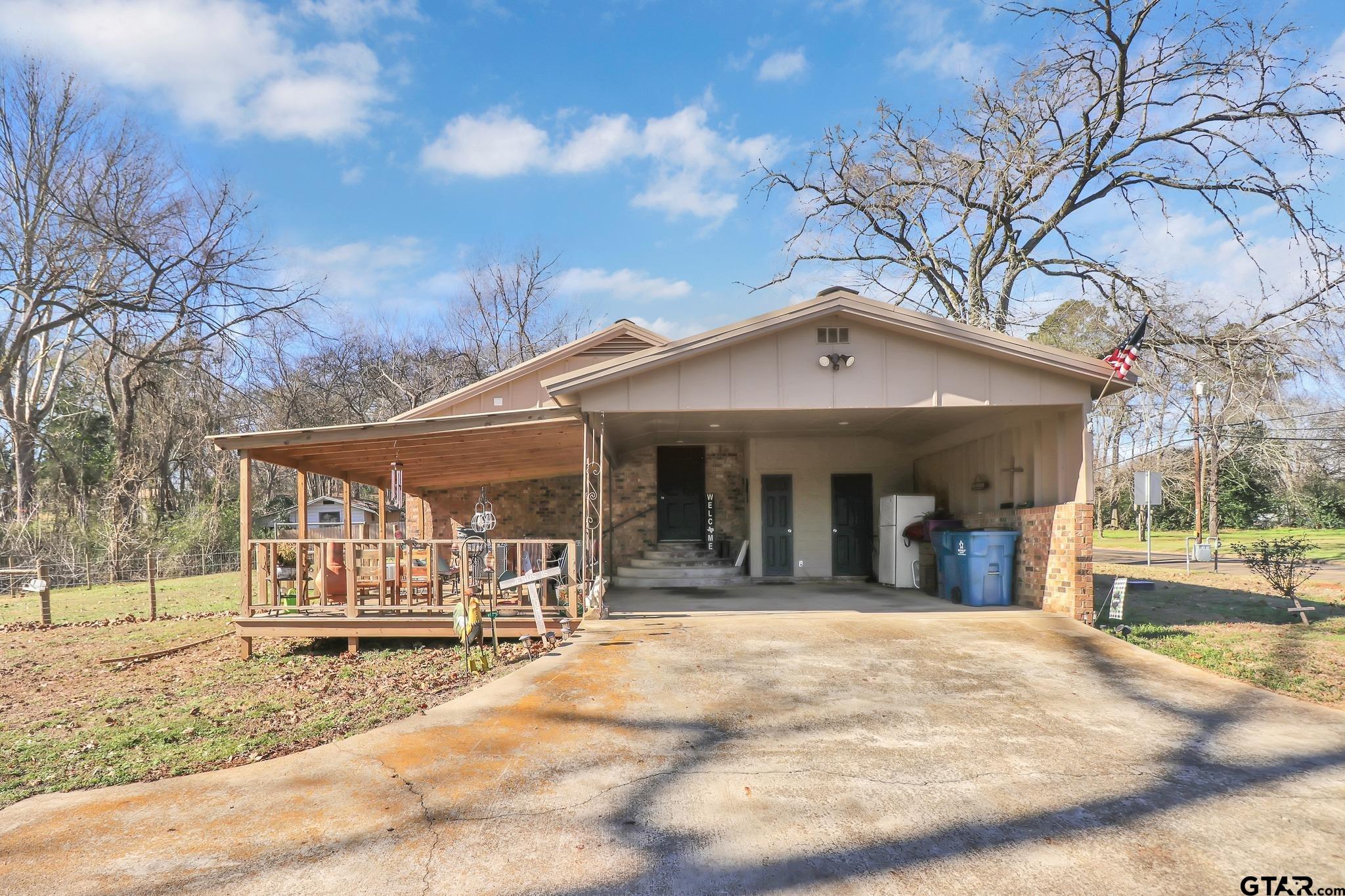 554 East San Antonio Street Alto, TX 75925 - Photo 25 of 28 a view of a white house with a large tree and wooden fence